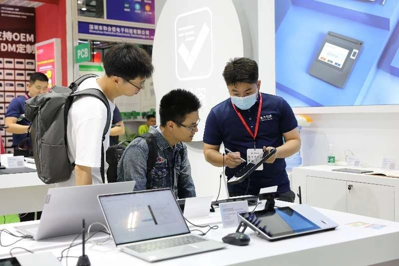 Haveways staff demonstrating a digital signature pad for trade show visitors